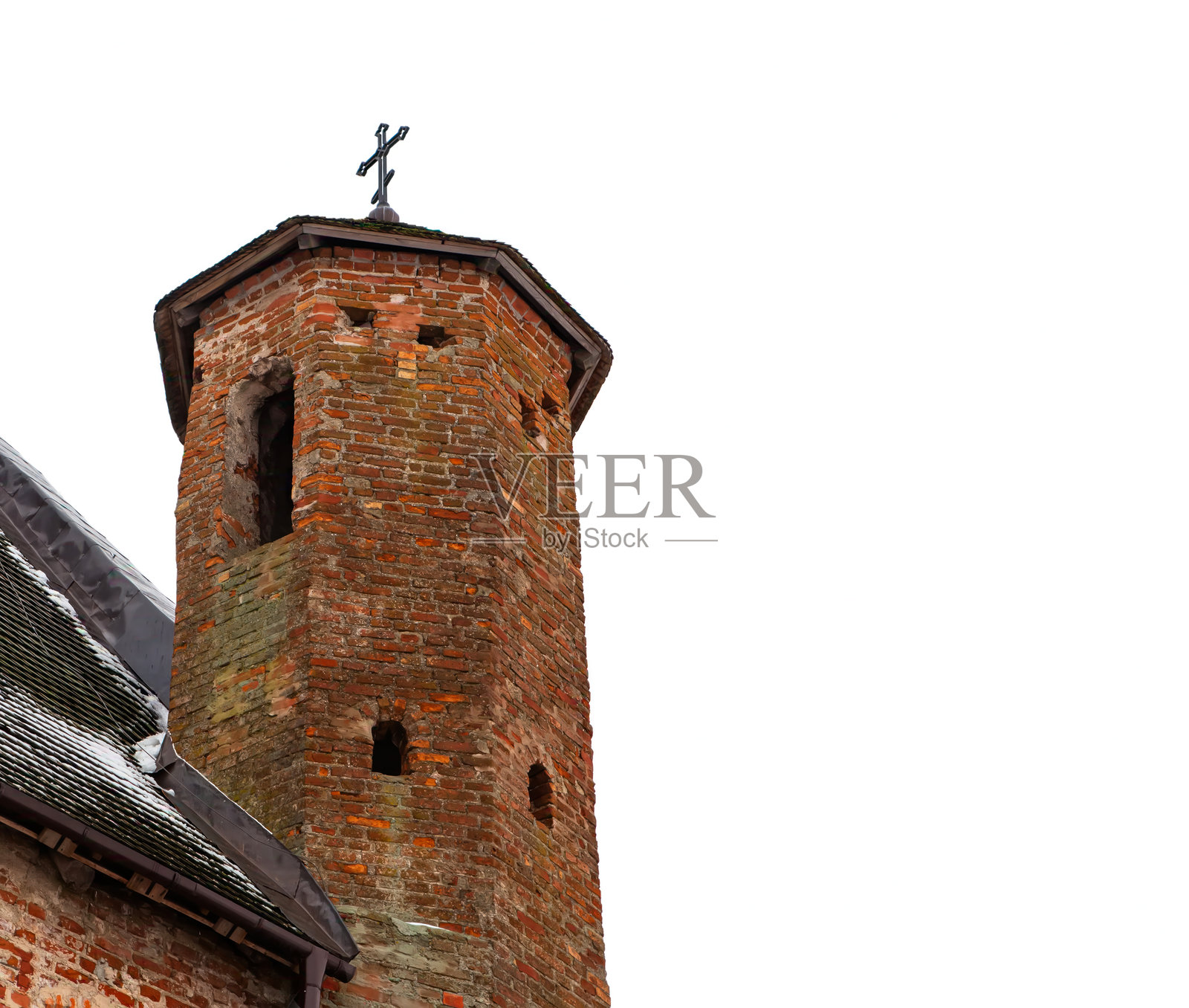 古老的教堂塔楼在多云的天空下高耸,顶部有十字架,坐落于一个宁静的村庄里照片摄影图片