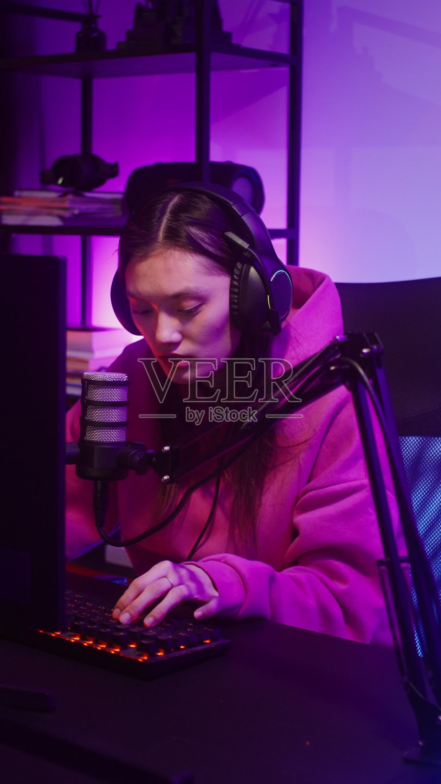 佩戴耳机的年轻女子对着麦克风说话 - 游戏照片摄影图片