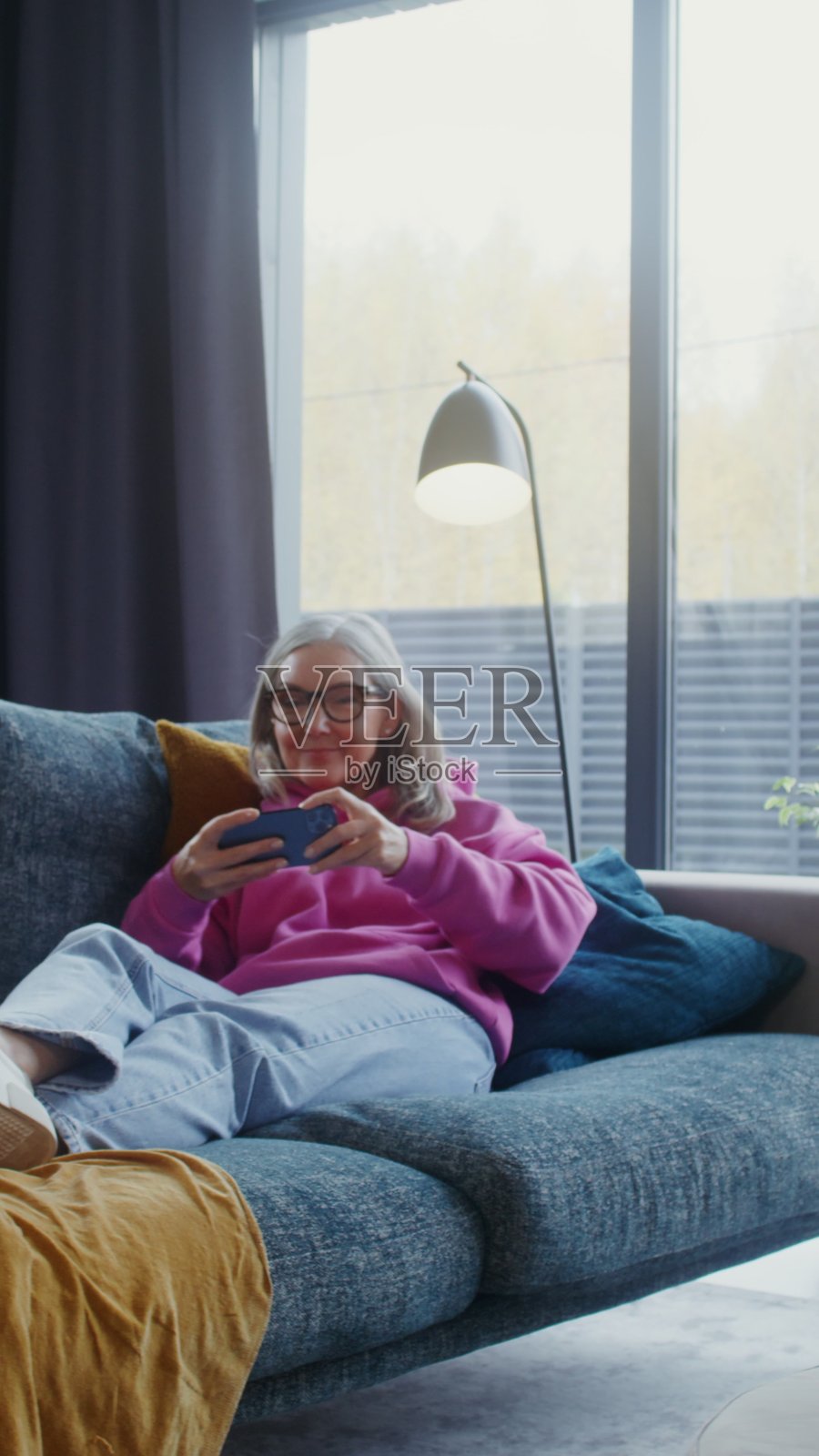 老年妇女躺着玩手机 - 游戏照片摄影图片