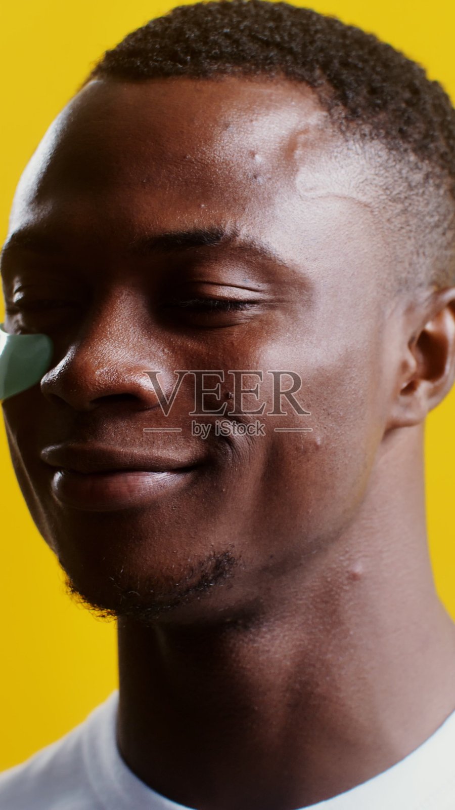 一个男人在眼下贴上保湿眼膜——呵护。照片摄影图片