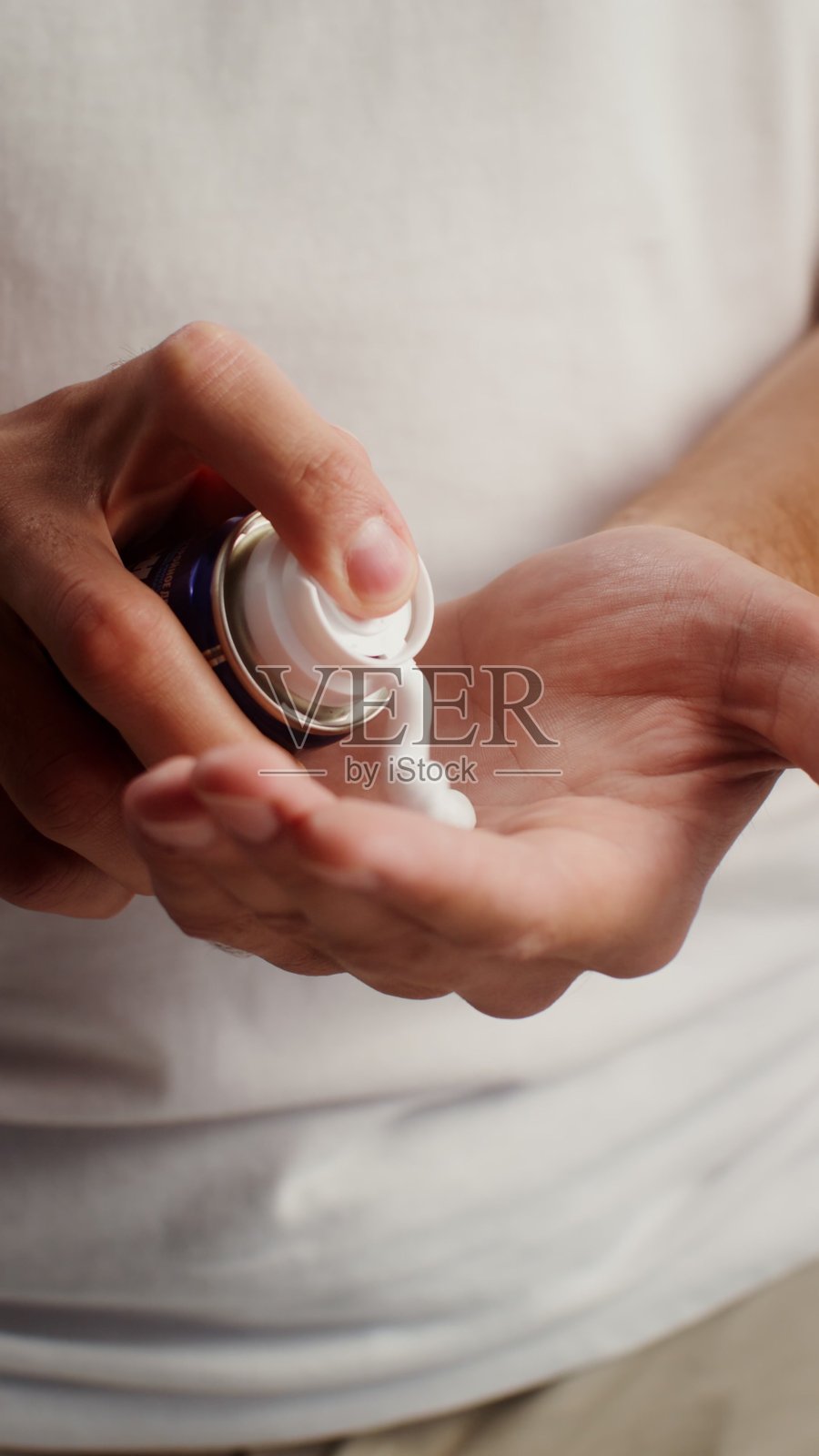 一个男人将剃须泡沫挤到手掌中——呵护。照片摄影图片