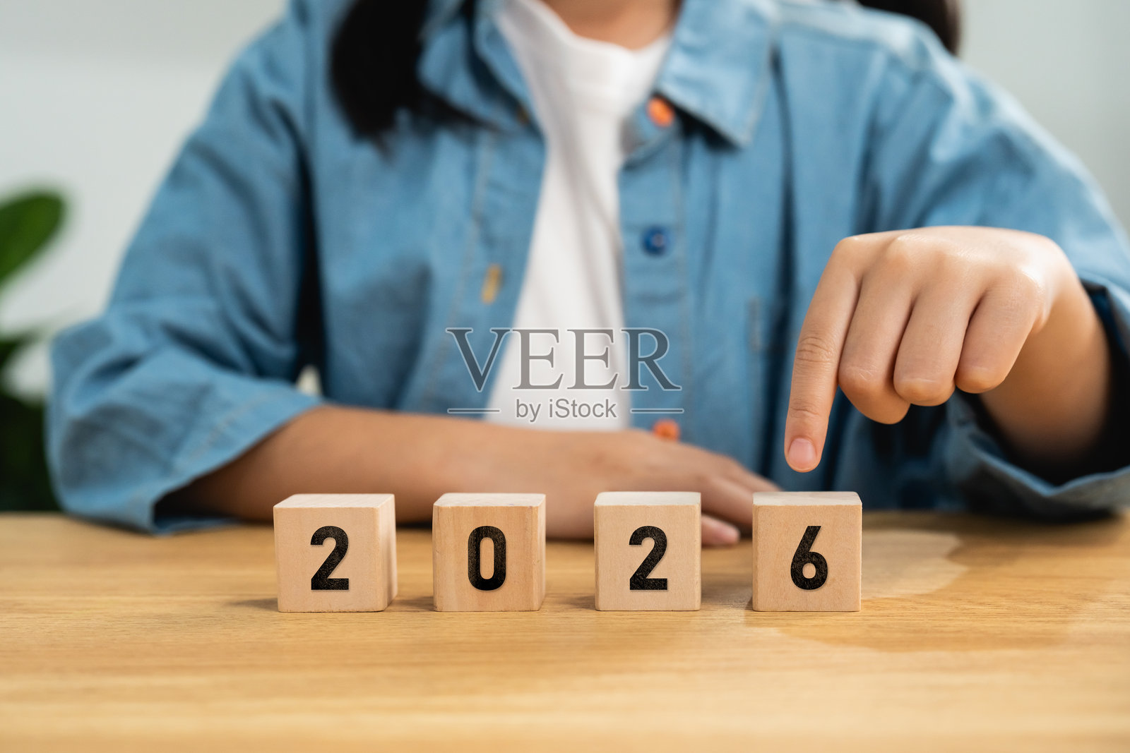 2026新年概念。孩子的手指向木制数字积木。象征着未来计划、日历日期、教育和新年时间线。照片摄影图片