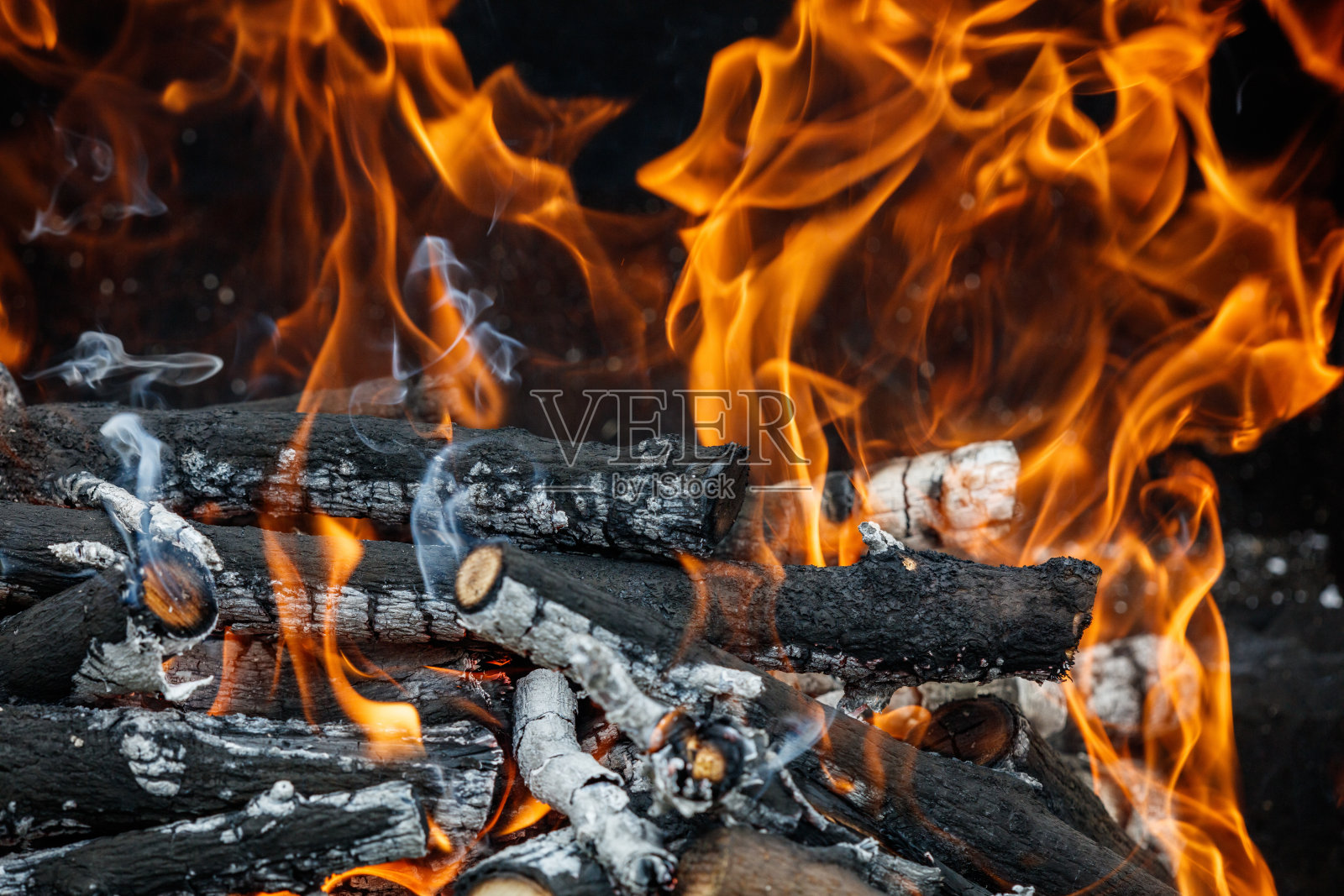 一堆着火的木头,火焰直冲云霄照片摄影图片
