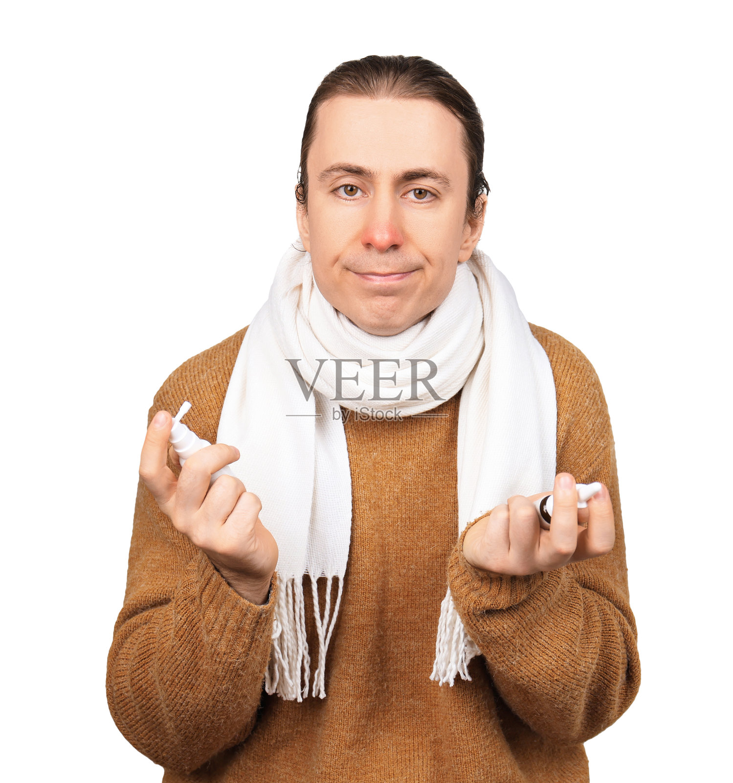 一个生病的男人,红着鼻子,拿着两个喷雾剂,在白色背景上选择药物。照片摄影图片