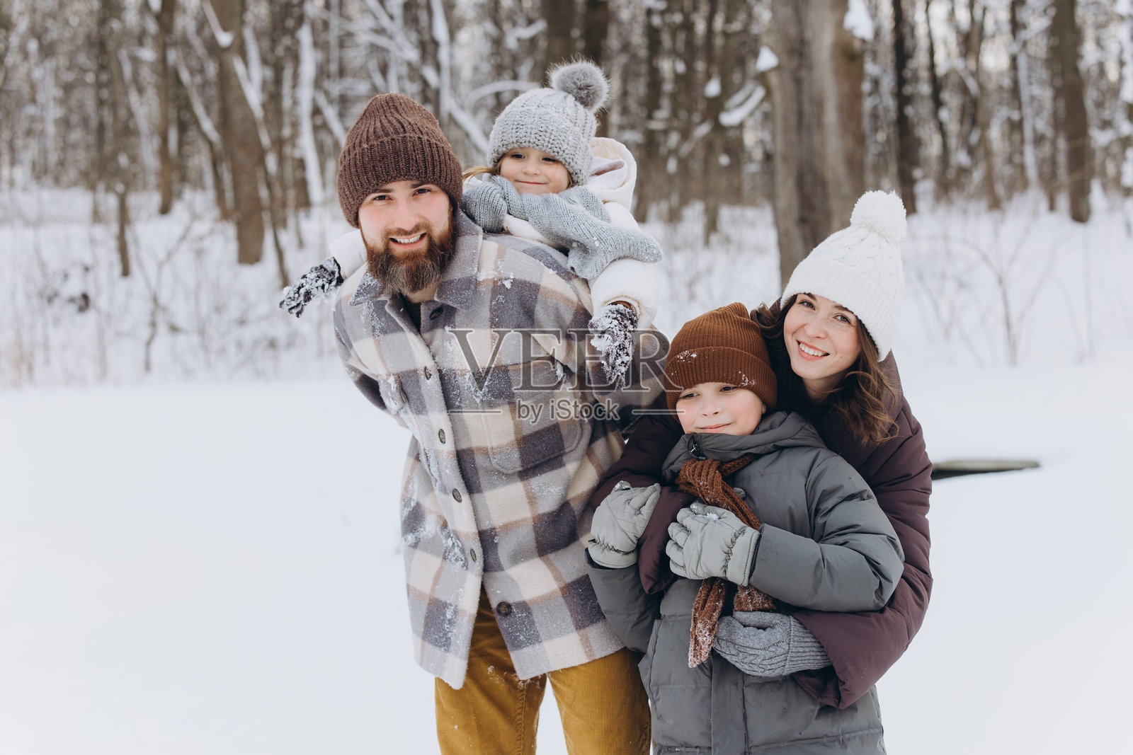 快乐的家庭在雪林中享受冬日漫步照片摄影图片