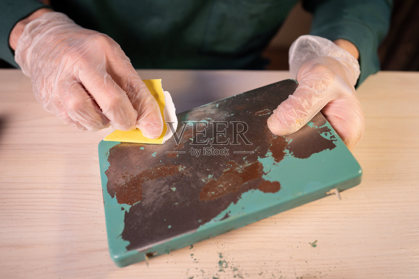 男人在家里的工作室工作,用砂纸打磨灯座表面,创意修复过程。照片摄影图片