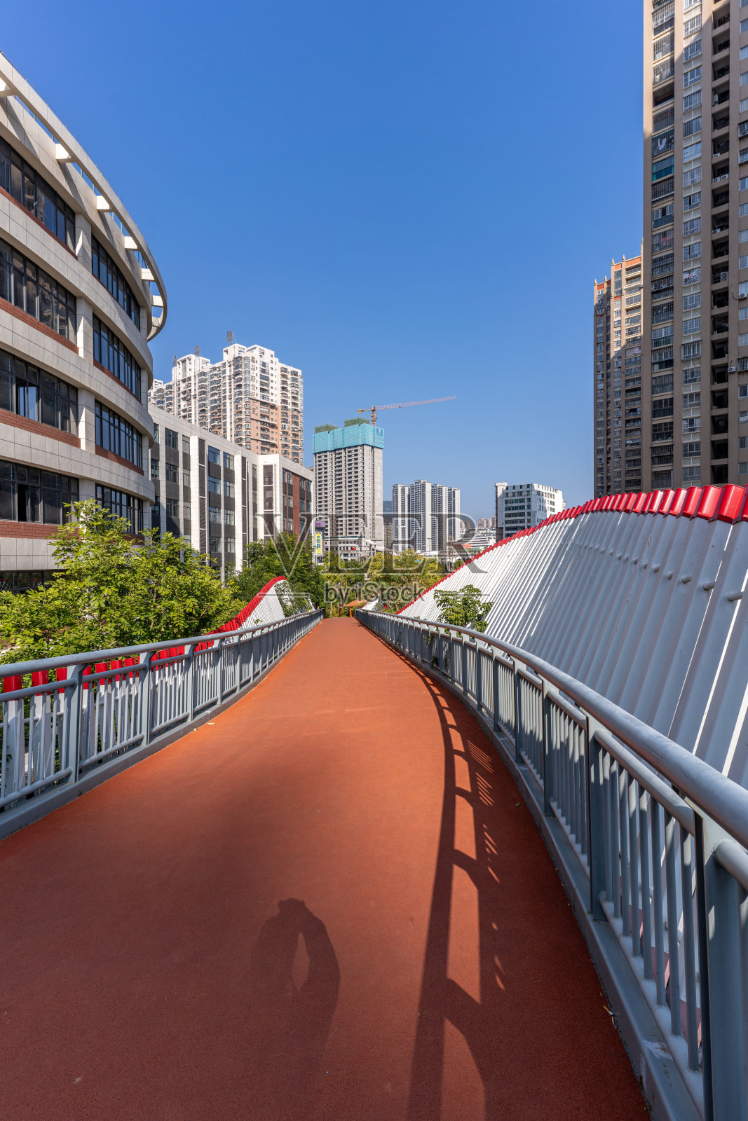 红色的沥青路和周围的城市建筑照片摄影图片