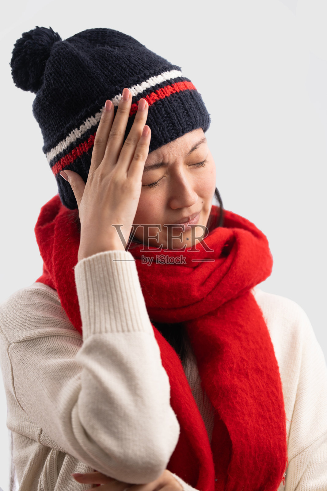 穿着冬装、头痛的年轻女子照片摄影图片