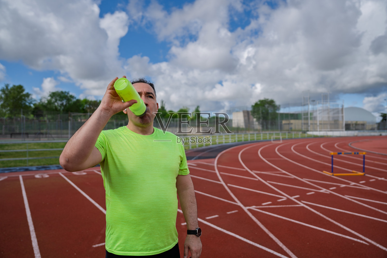 男人在户外跑道上喝水照片摄影图片