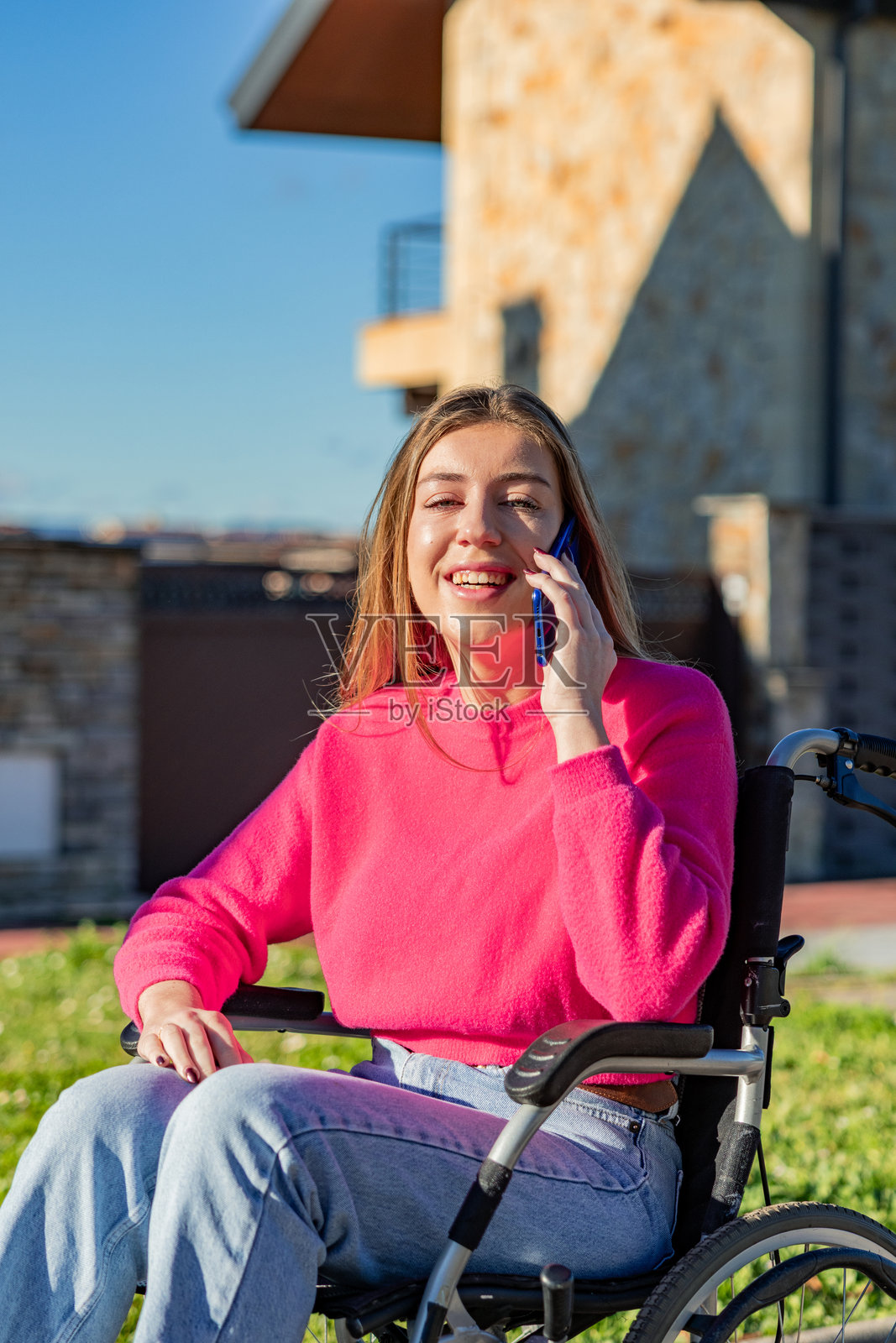 坐轮椅的年轻女子在户外用手机交谈照片摄影图片