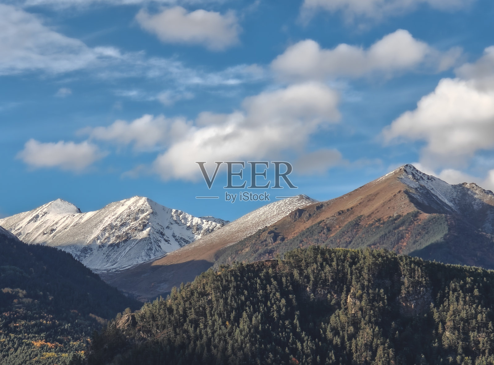 阴天时高加索山脉的风景,全景视图,山脉和林区有积雪。照片摄影图片