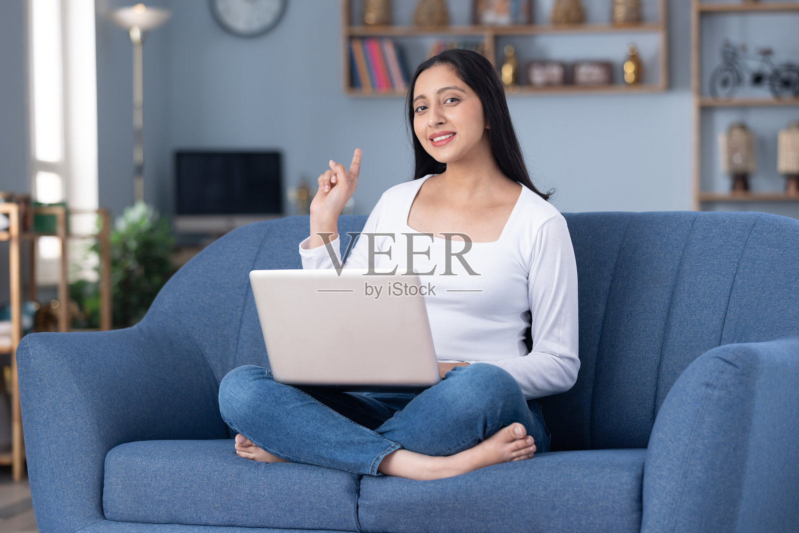 穿着时尚的漂亮年轻女孩在家中沙发上使用笔记本电脑的图片素材照片摄影图片