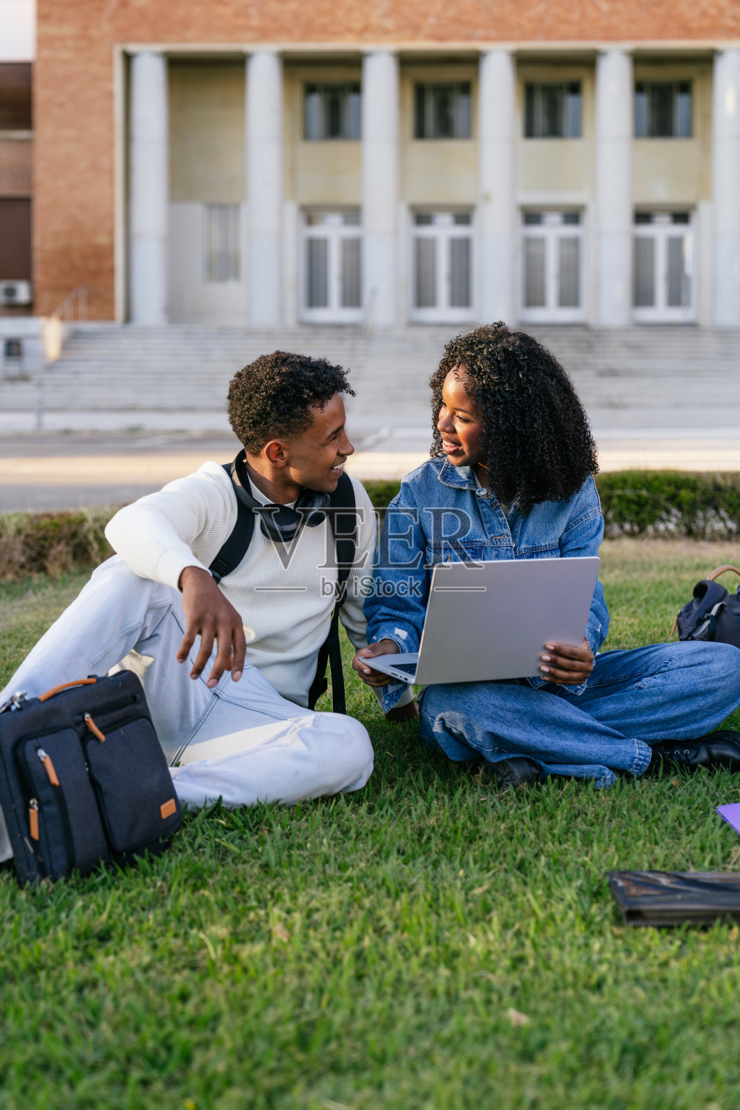 不同背景的学生们在大学校园的草地上一起学习照片摄影图片