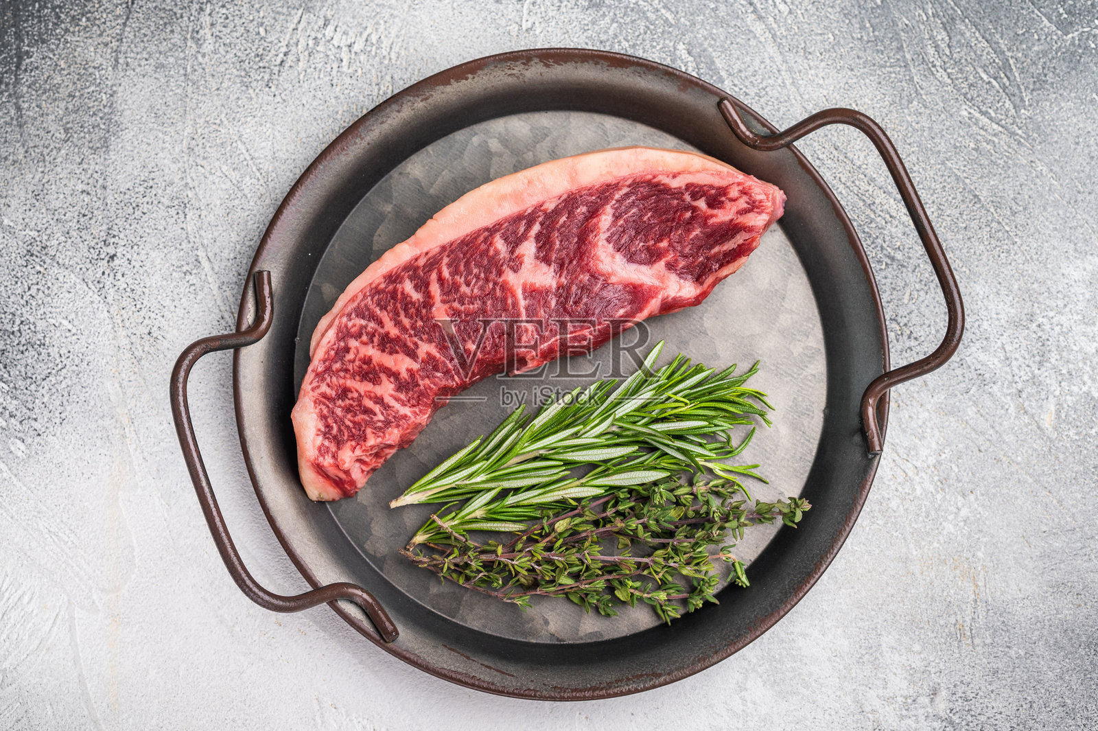 生臀盖牛排,牛肉,展示其丰富的颜色和纹理。灰色背景。俯视角度。照片摄影图片