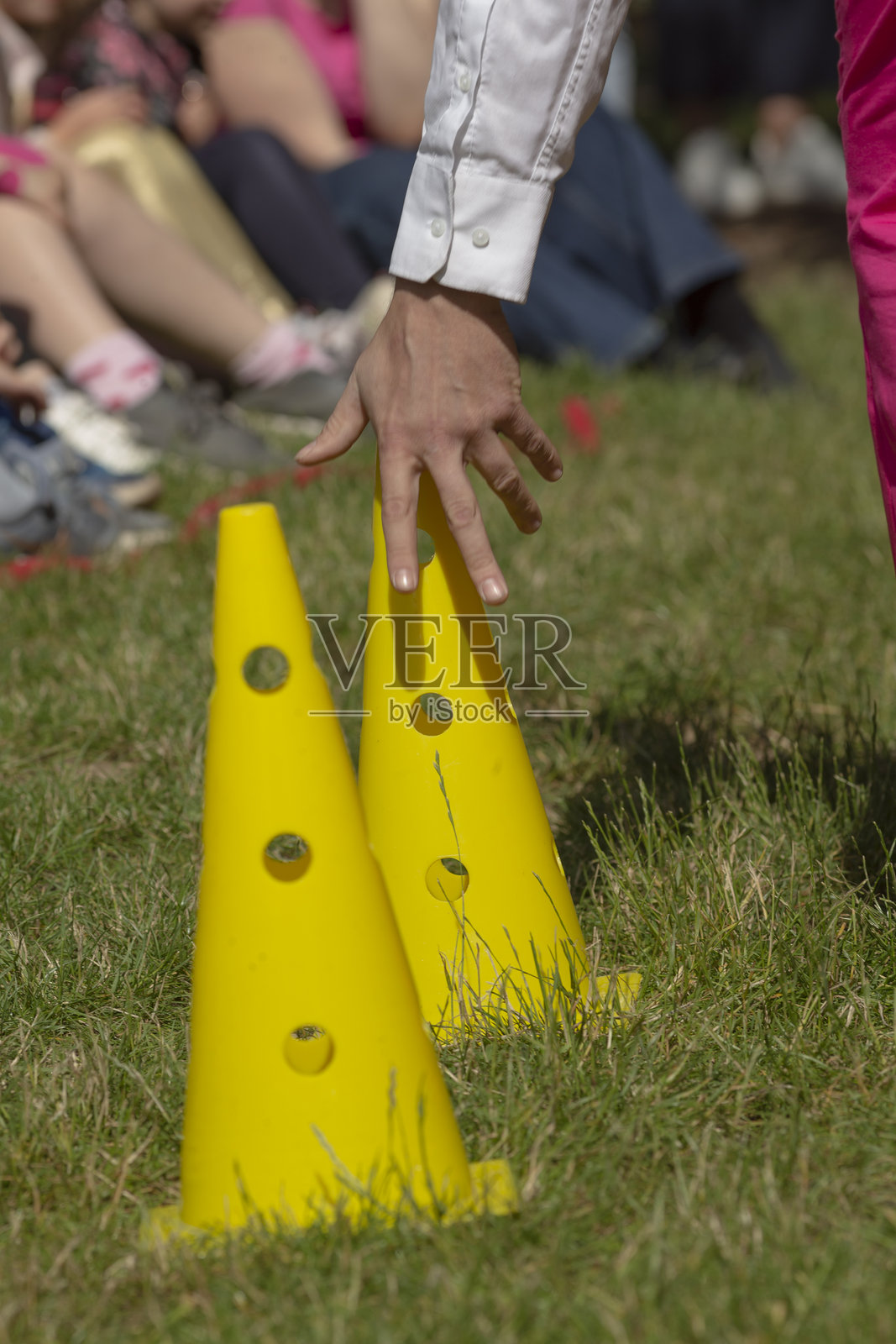 孩子们看着大人们在户外为团队活动布置锥形桶照片摄影图片