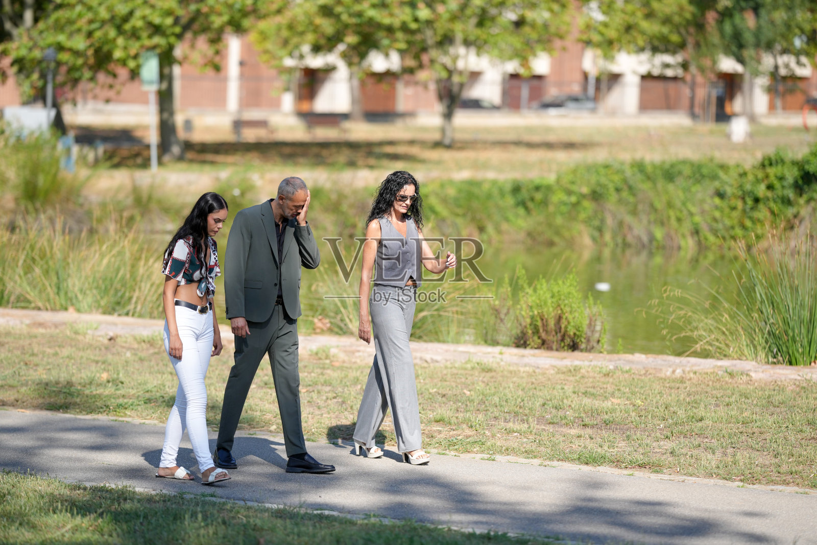 一对夫妇和一个孩子在公园里一起散步照片摄影图片