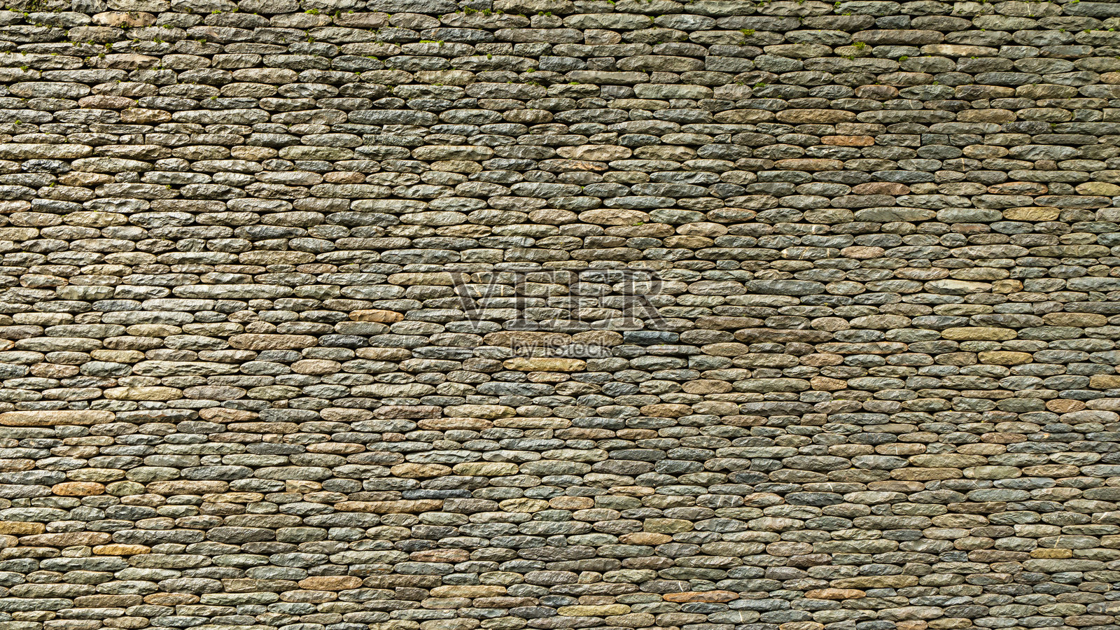 老旧堆叠石墙纹理背景,带有天然岩石图案。照片摄影图片