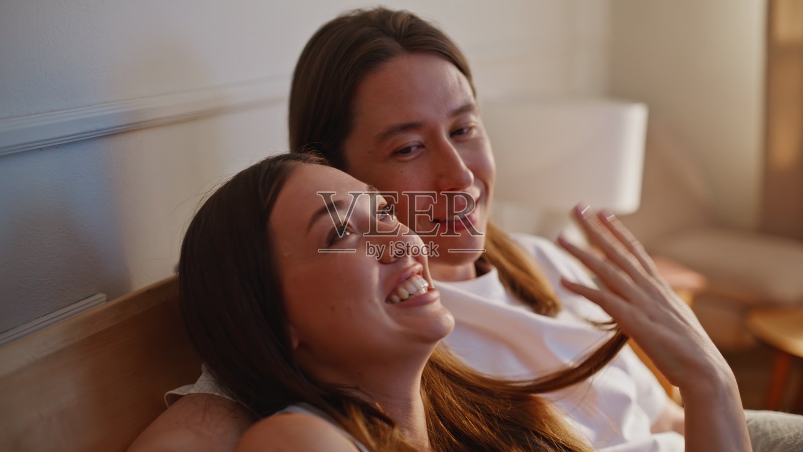 亲密爱人清晨依偎在毯子上,特写镜头。男子拥抱着微笑的女子照片摄影图片