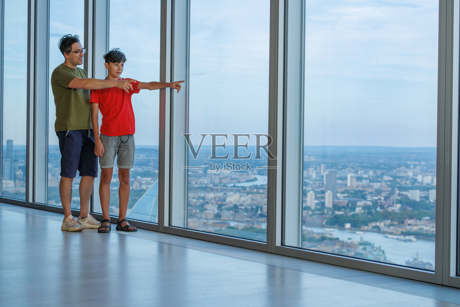 父子游客在高层建筑欣赏城市景观照片摄影图片