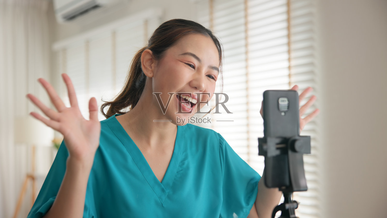 年轻亚裔女性,Z世代,亚洲人,抗衰老专家,现代护士,进行直播,分享病毒式视频,自拍,手机应用,心理健康护理。在线分享,数字虚拟亚洲网红拍摄。照片摄影图片