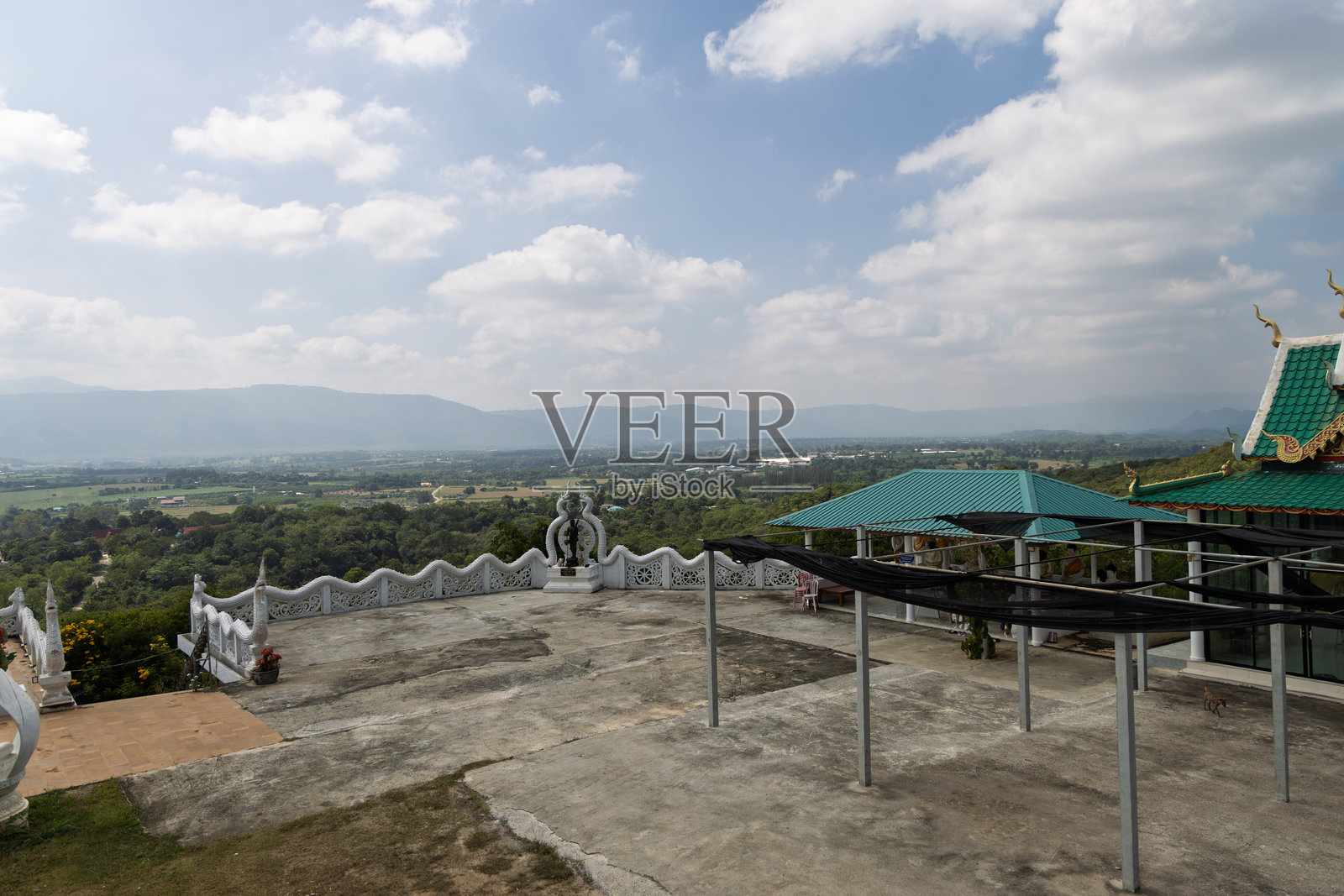 泰国考艾寺庙观景点,俯瞰郁郁葱葱的景观,可见绿色屋顶建筑和白色栏杆照片摄影图片