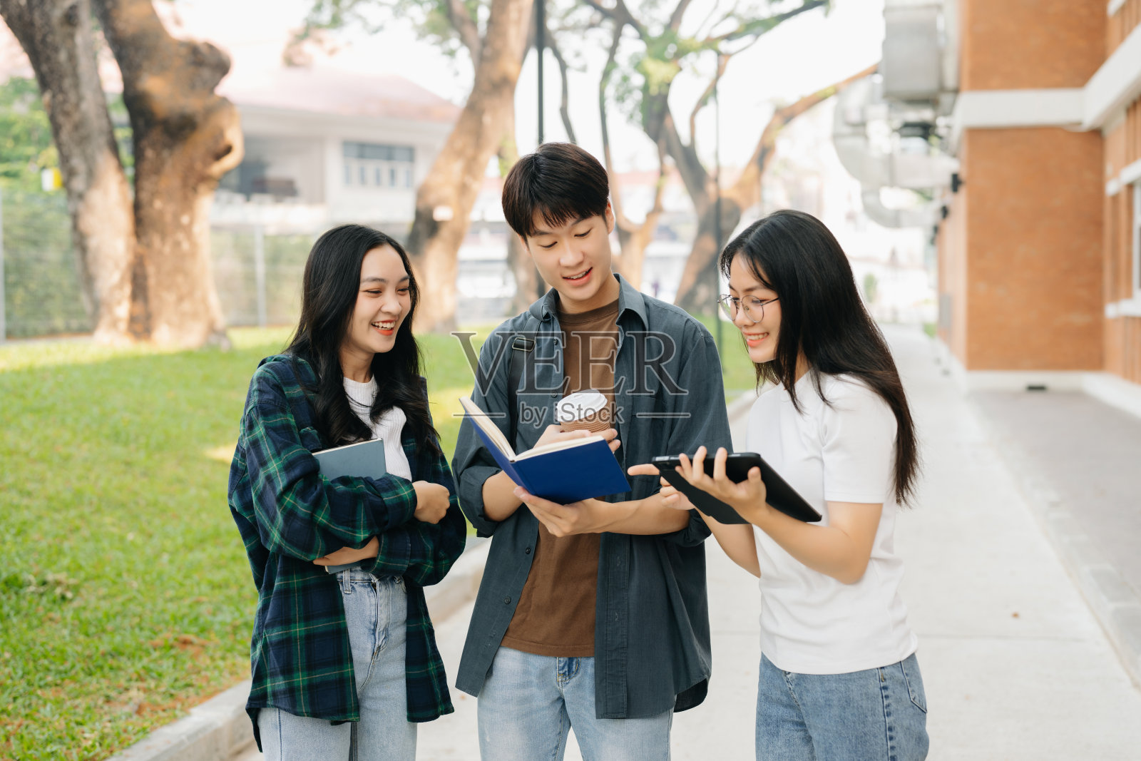 年轻的亚洲大学生和一群女学生在校园公园里学习照片摄影图片