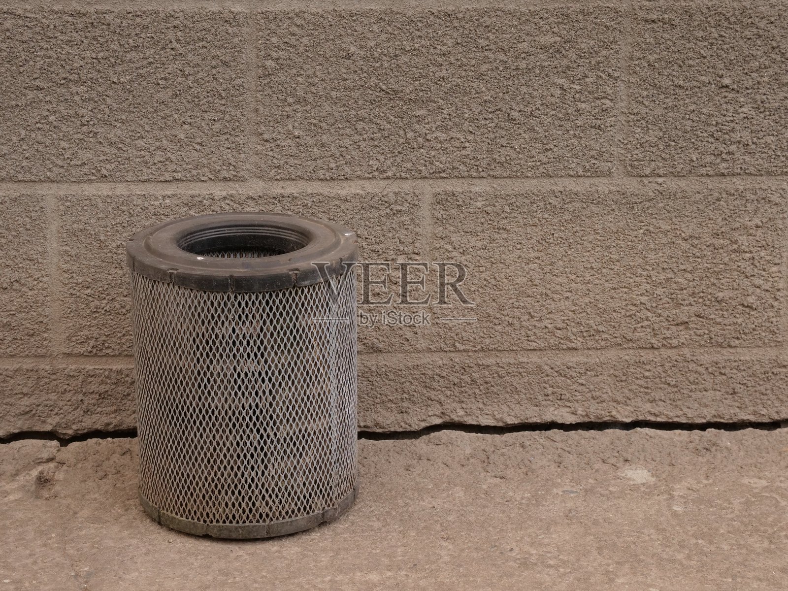 圆柱形空气过滤器竖立在混凝土上,靠近纹理墙,工业极简风格,带有复制空间。照片摄影图片