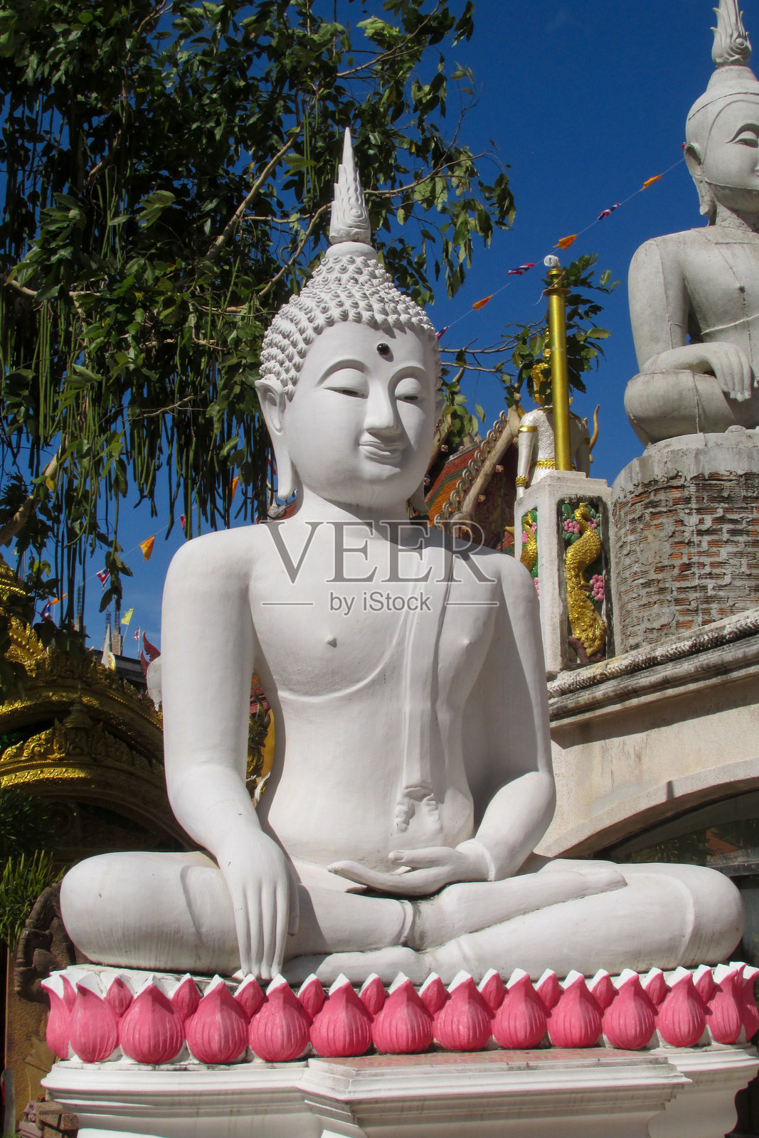 泰国寺庙中带有传统佛教设计、金色表面和建筑细节的佛像照片摄影图片