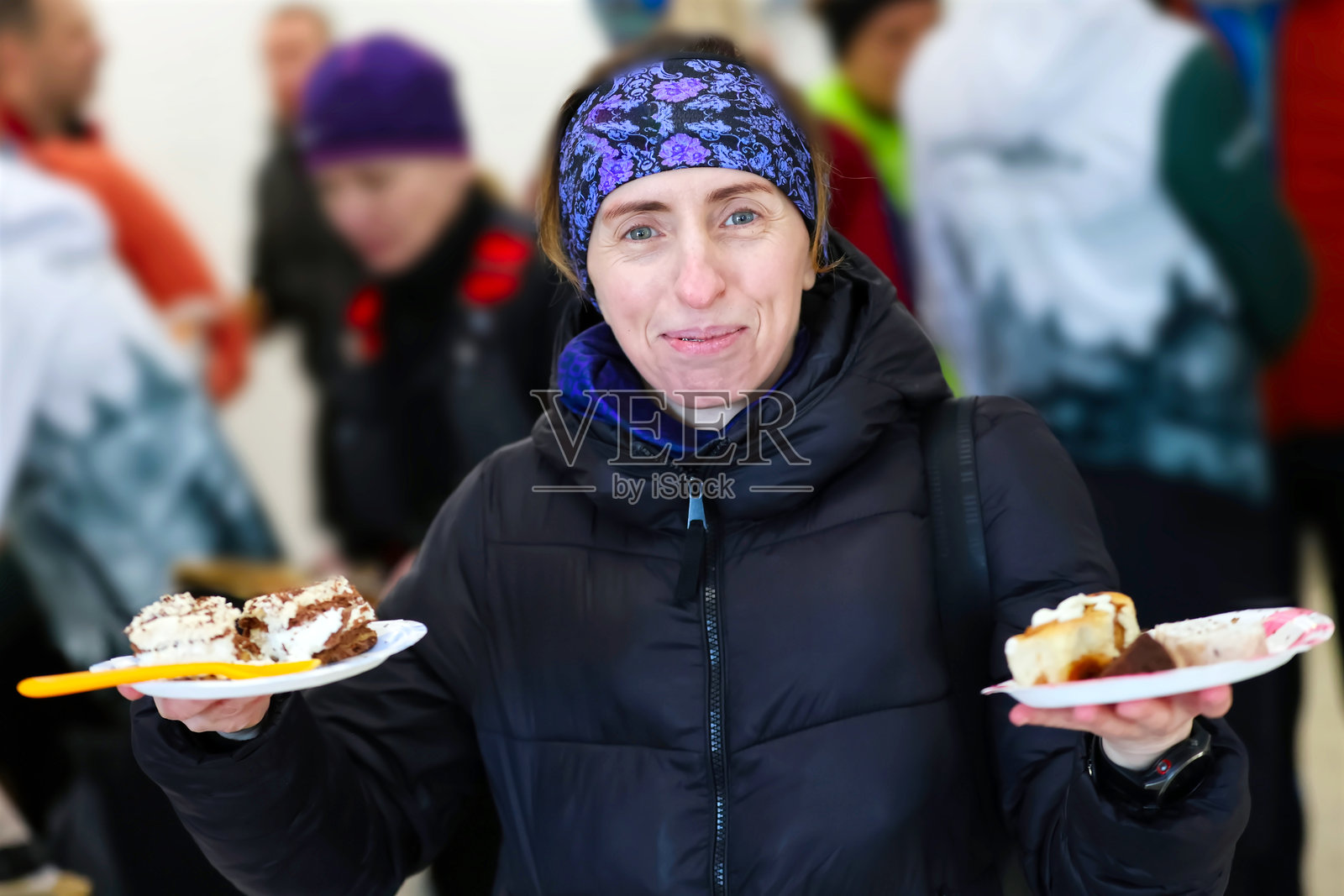 派对上,一位快乐的女士端着两盘美味的甜点照片摄影图片