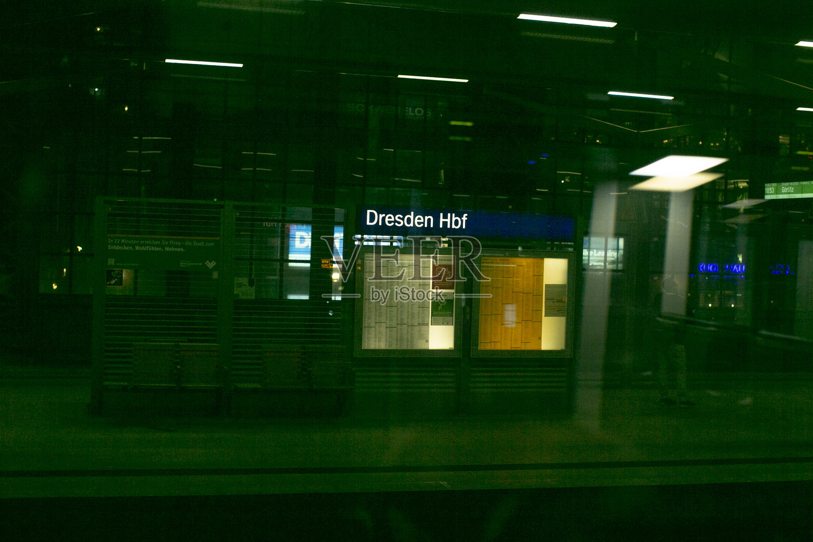 夜幕下的德累斯顿火车站,灯火辉煌的指示牌和空旷的候车区照片摄影图片