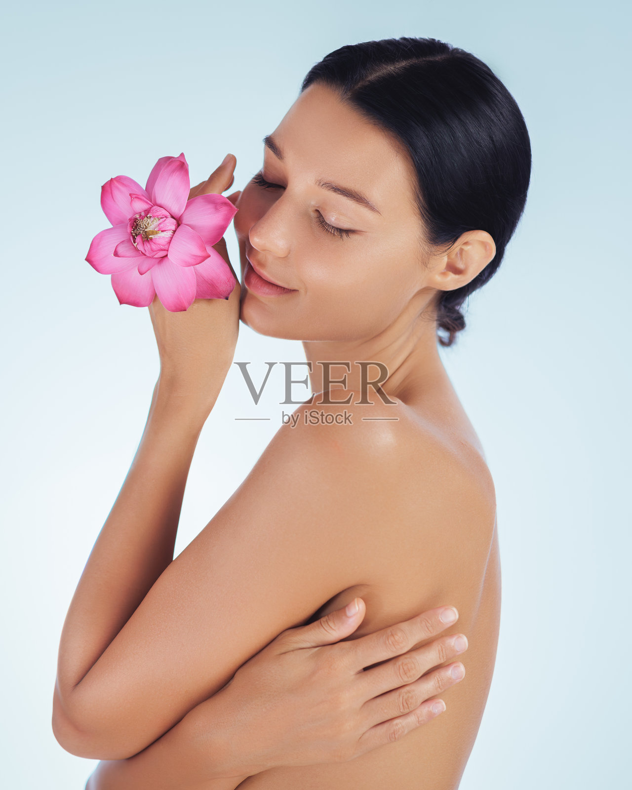 闭着眼睛的漂亮女人和莲花,展现出柔软滋润的肌肤照片摄影图片