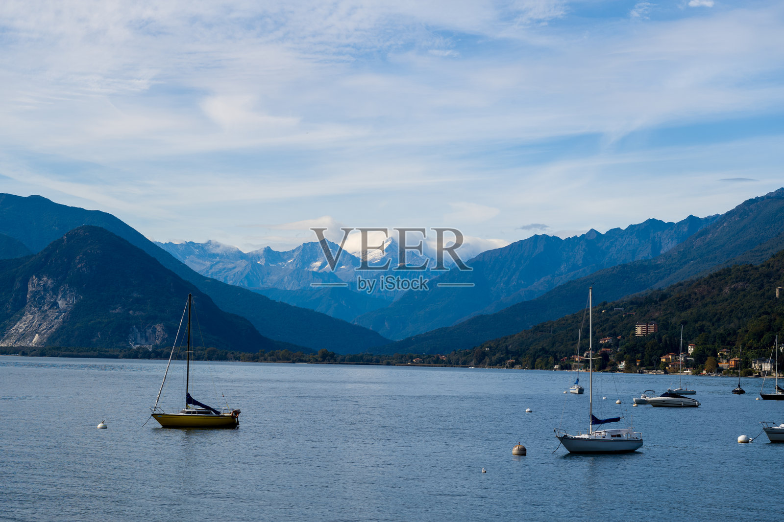 停泊在马焦雷湖上的帆船与阿尔卑斯山照片摄影图片