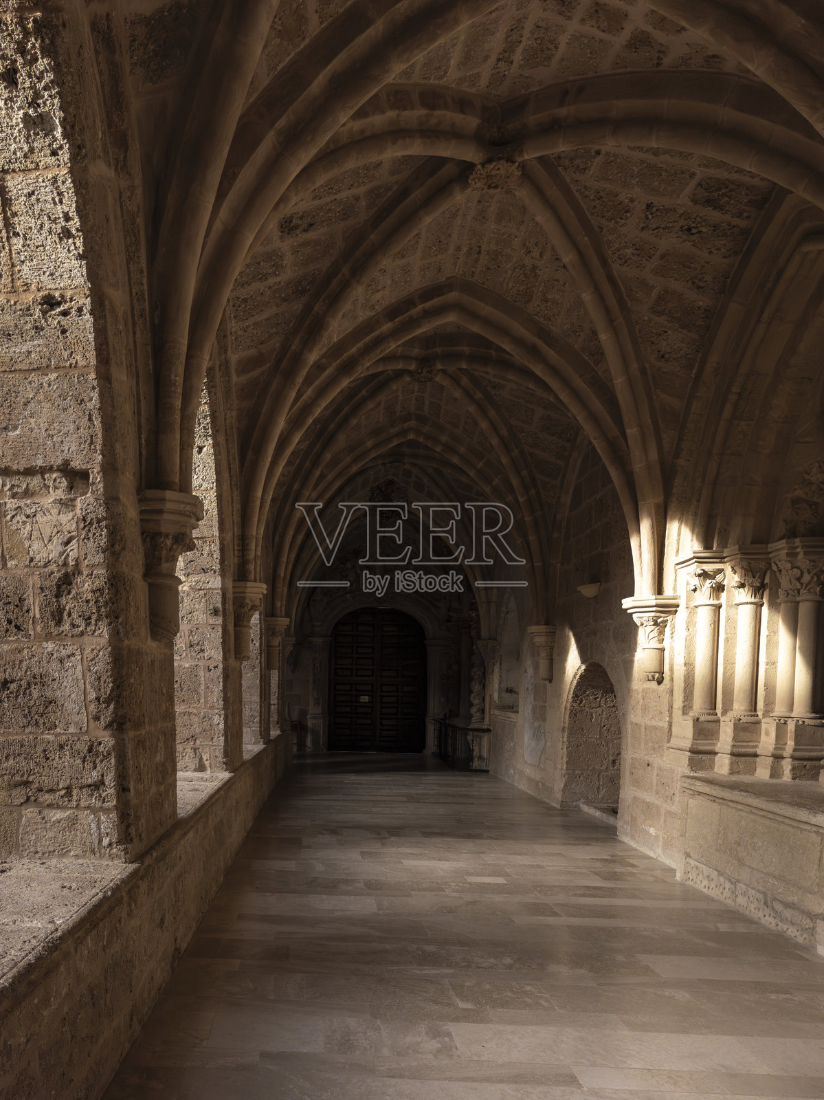 哥特式修道院走廊拱门,带有石柱细节照片摄影图片