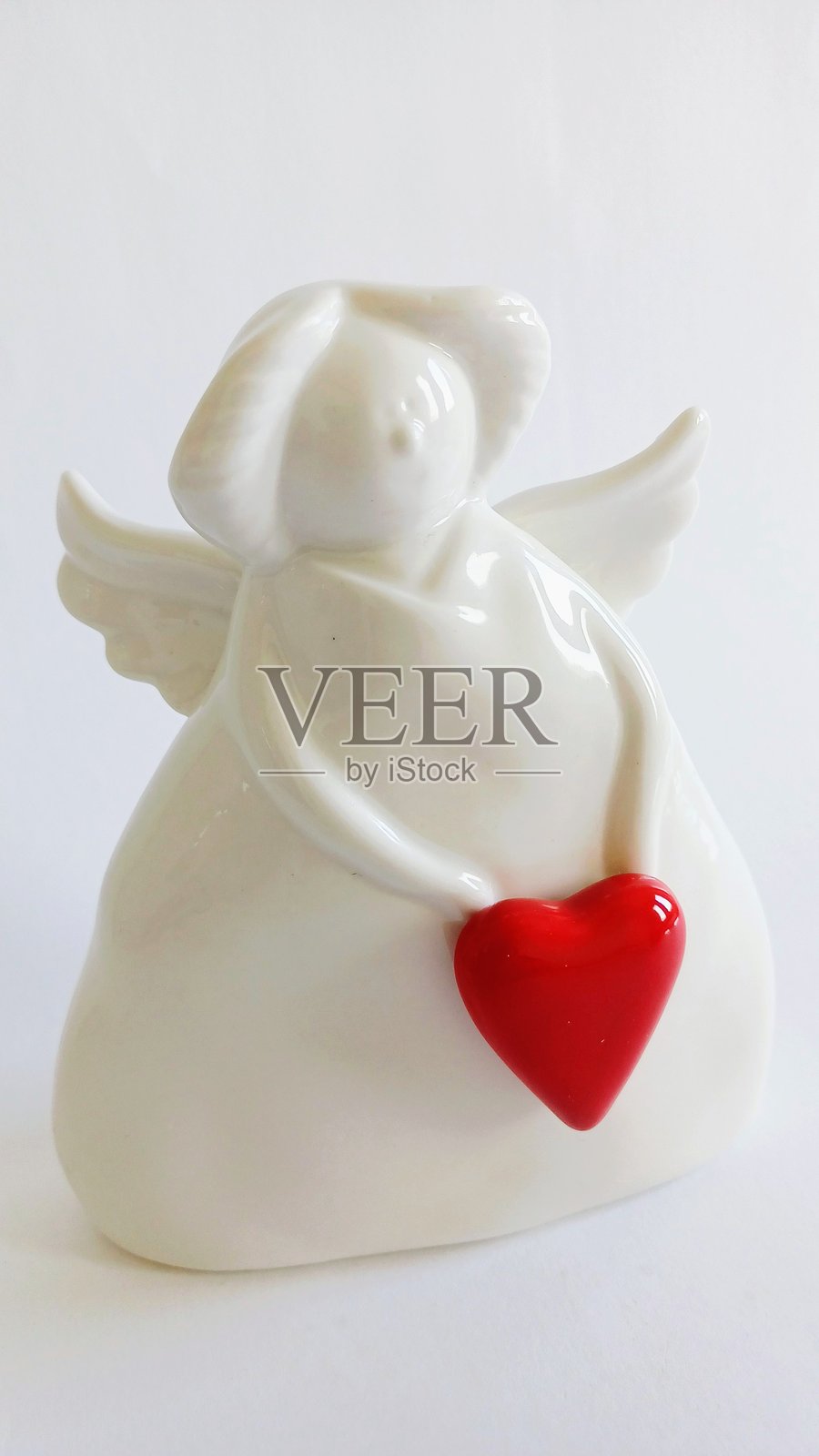 白色陶瓷天使小雕像,背景为白色照片摄影图片