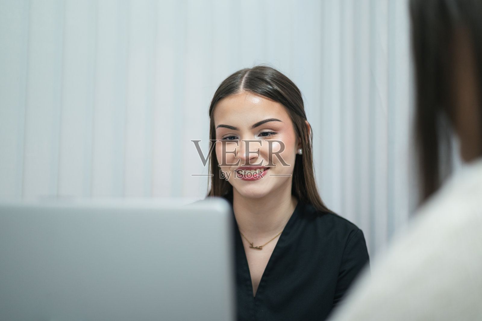 美容师在咨询客户关于皮肤护理时面带微笑照片摄影图片