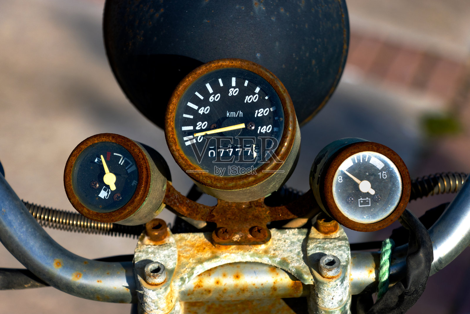 复古摩托车仪表盘特写,生锈的仪表显示燃油低、电压低和20公里/小时的速度——非常适合复古主题的背景使用和机械纹理构图。照片摄影图片