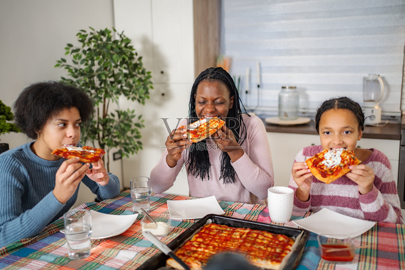 非洲裔美国家庭在家中一起享用自制披萨照片摄影图片