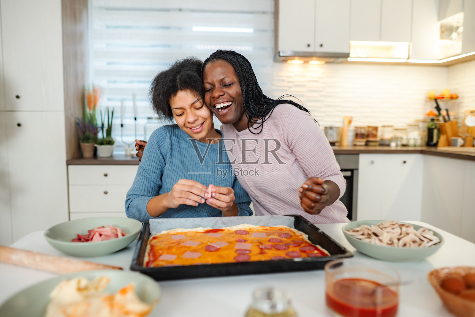 母女俩在厨房里铺开食材,在烘焙中享受亲子时光照片摄影图片