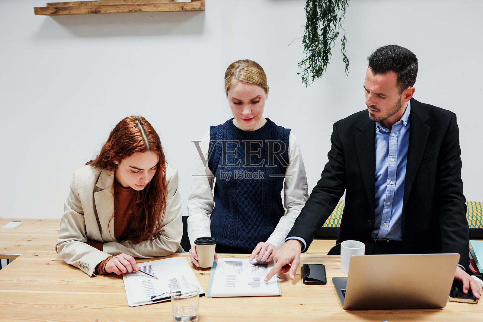 一群不同年龄的西班牙裔商务团队在办公室一起工作并使用笔记本电脑。多元化的创业者和跨代团队分享想法。照片摄影图片