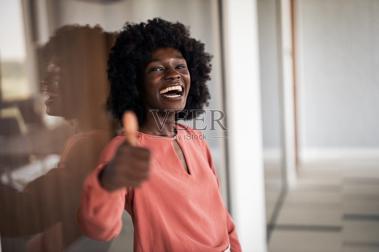 快乐的黑人女性在办公室竖起大拇指照片摄影图片