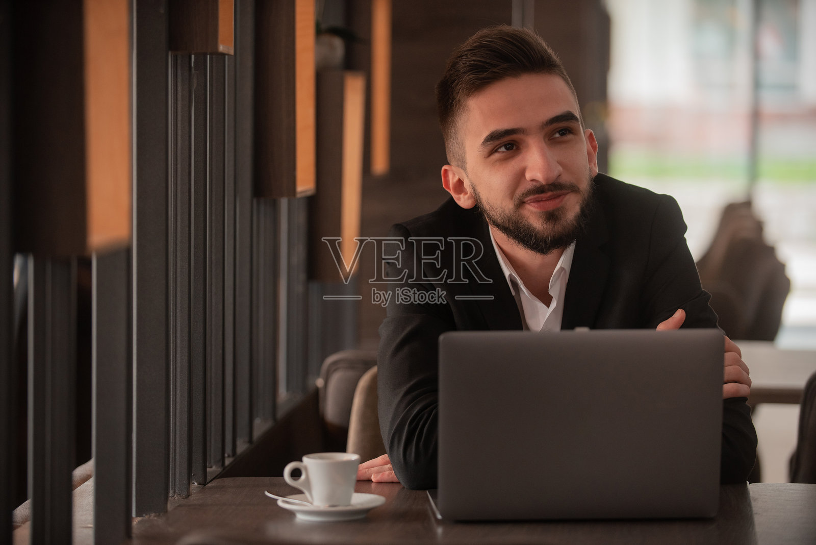 年轻的商务人士在办公室或咖啡馆的餐厅里用笔记本电脑工作。照片摄影图片