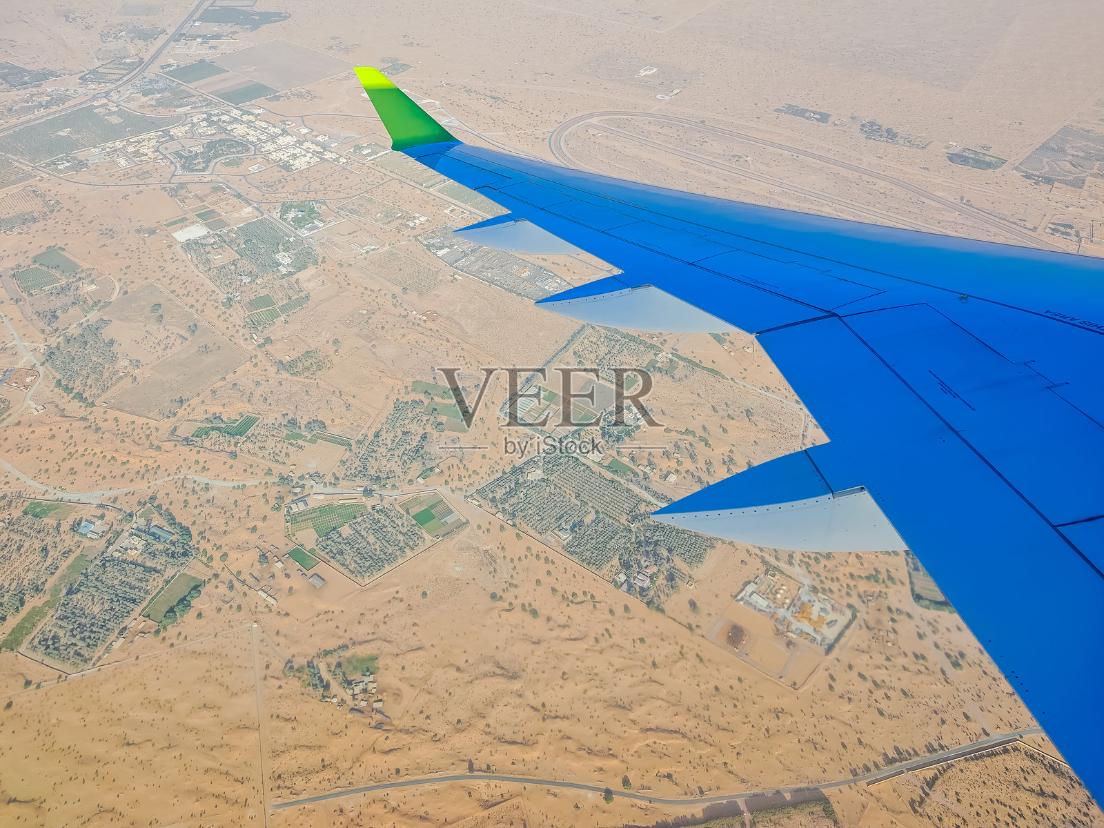 迪拜的空中景象。飞机正在降落迪拜,从飞机窗户看到的迪拜景色。照片摄影图片