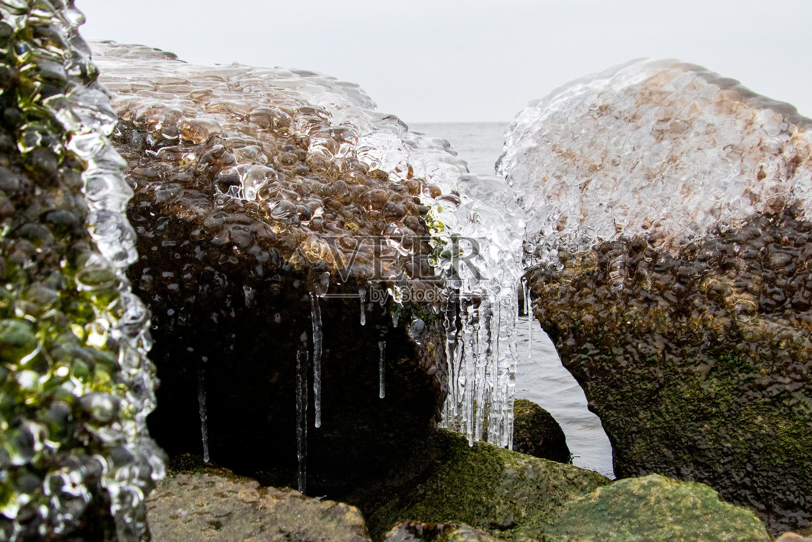 马克默湖海岸边的冰冻巨石和冰柱照片摄影图片