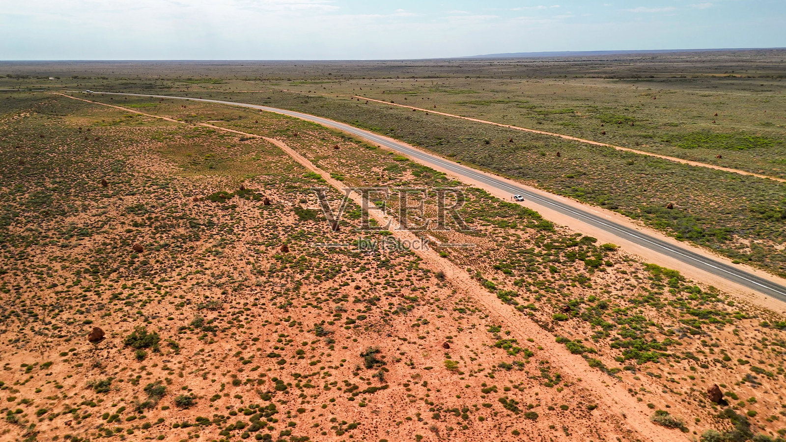 从空中俯瞰埃克斯茅斯路,可以看到西澳大利亚州干旱的内陆景观和标志性的白蚁丘点缀其间的高速公路照片摄影图片