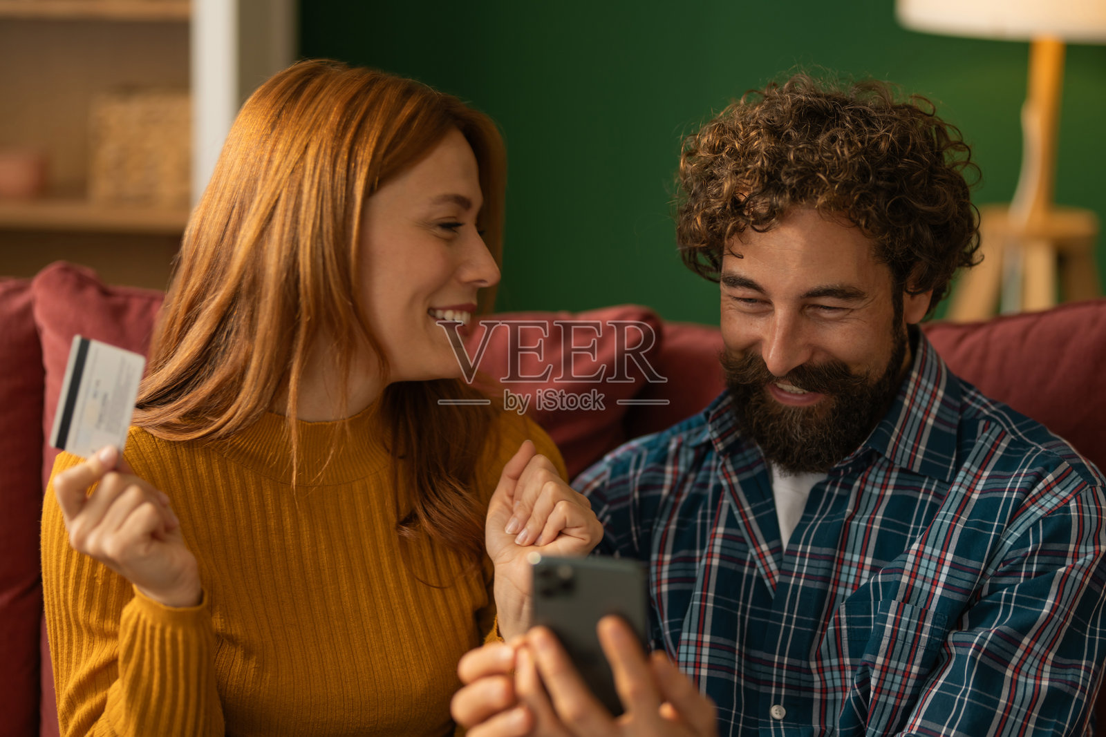 快乐的夫妇正在用信用卡网上购物照片摄影图片