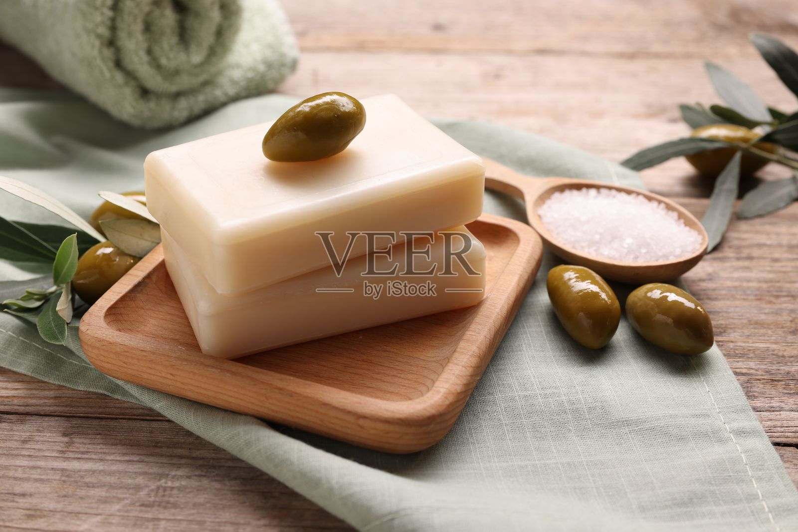 木桌上天然香皂、橄榄和海盐,特写照片摄影图片