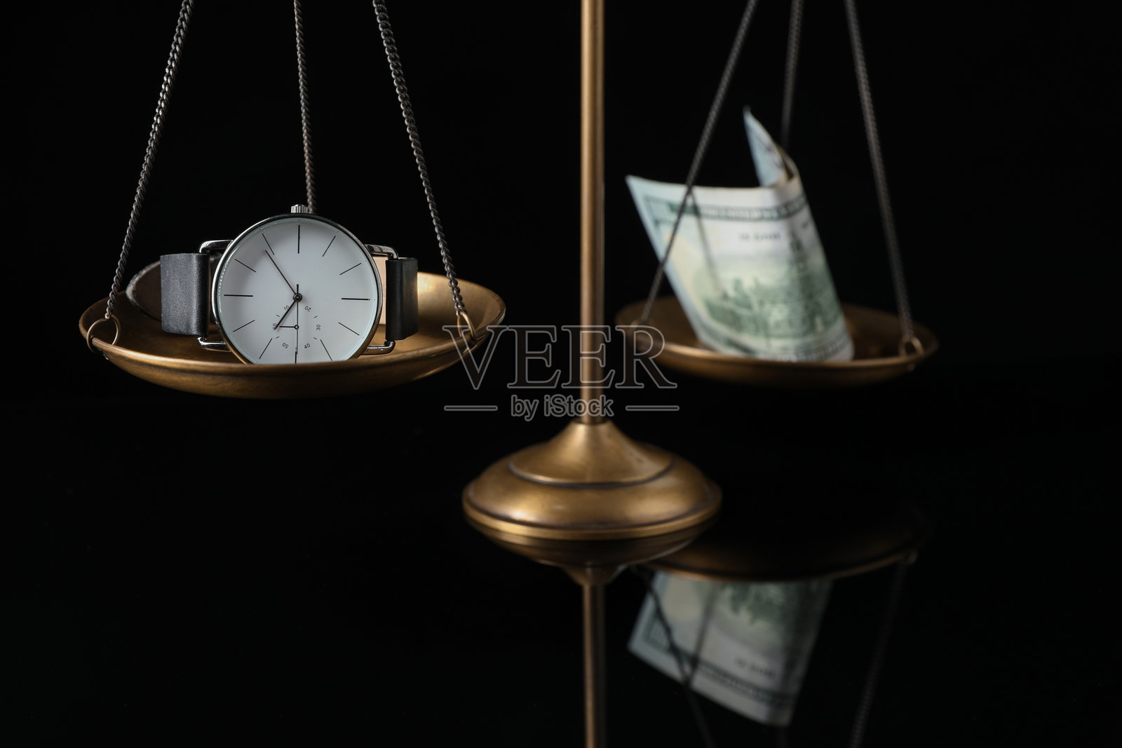 放在镜面上的天平、手表和金钱,黑色背景,特写照片摄影图片