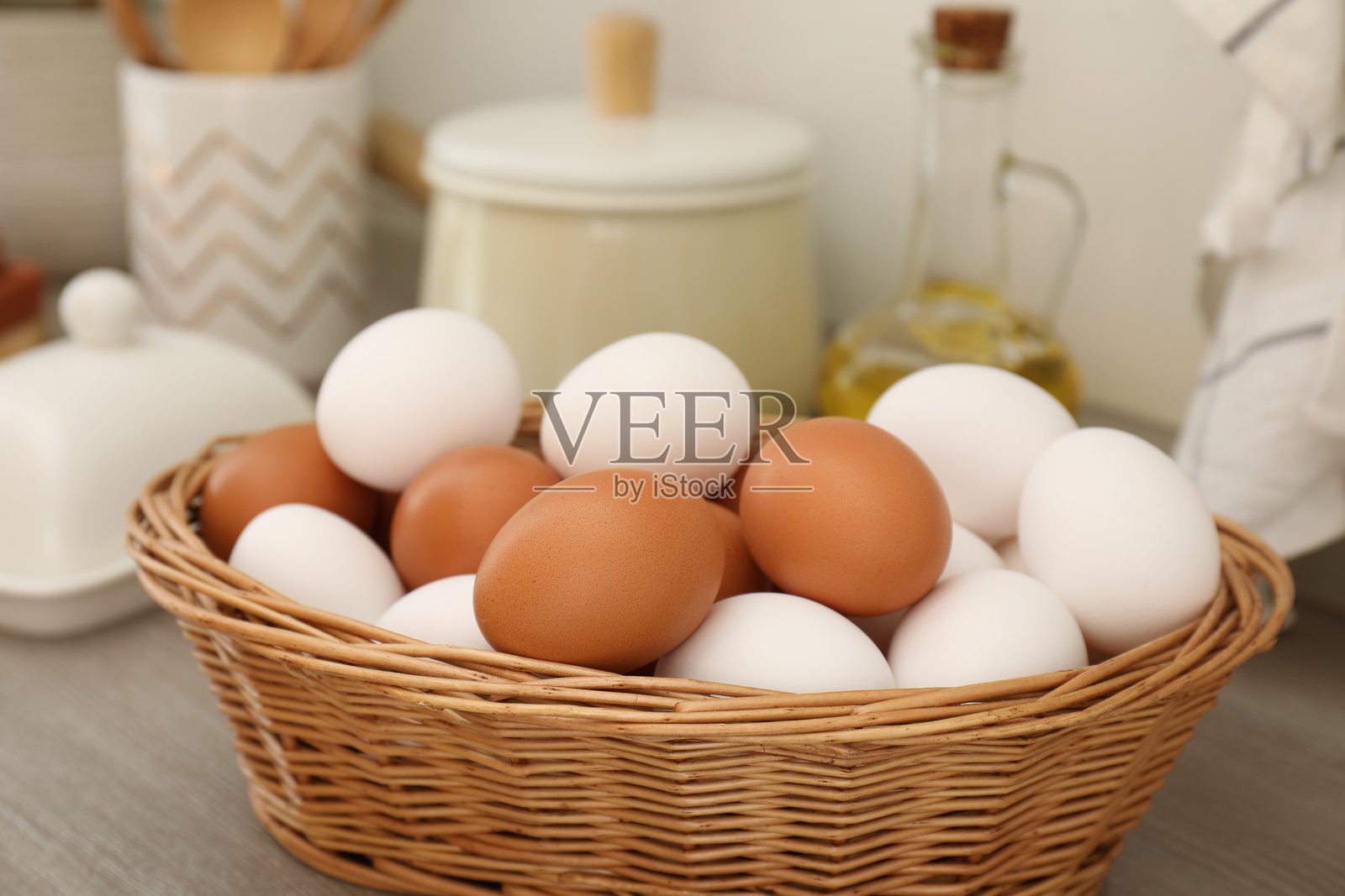 特写镜头:室内木质台面上柳条篮中的生鸡The translation of the input text is: 'Closeup: Raw chicken eggs in wicker basket on wooden counter indoors.'照片摄影图片