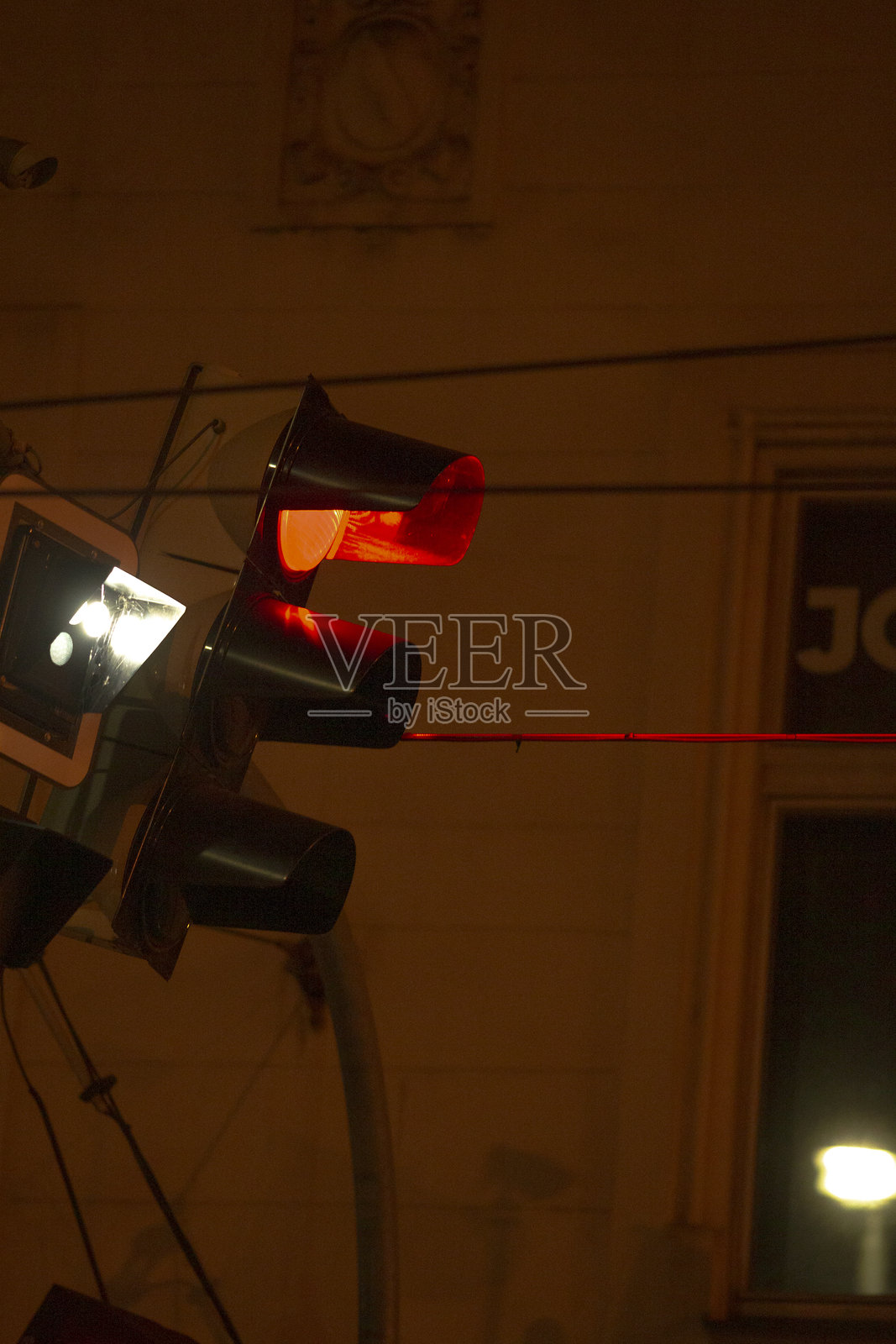 夜晚的城市景观,红色的交通信号灯闪烁着反光的光芒照片摄影图片