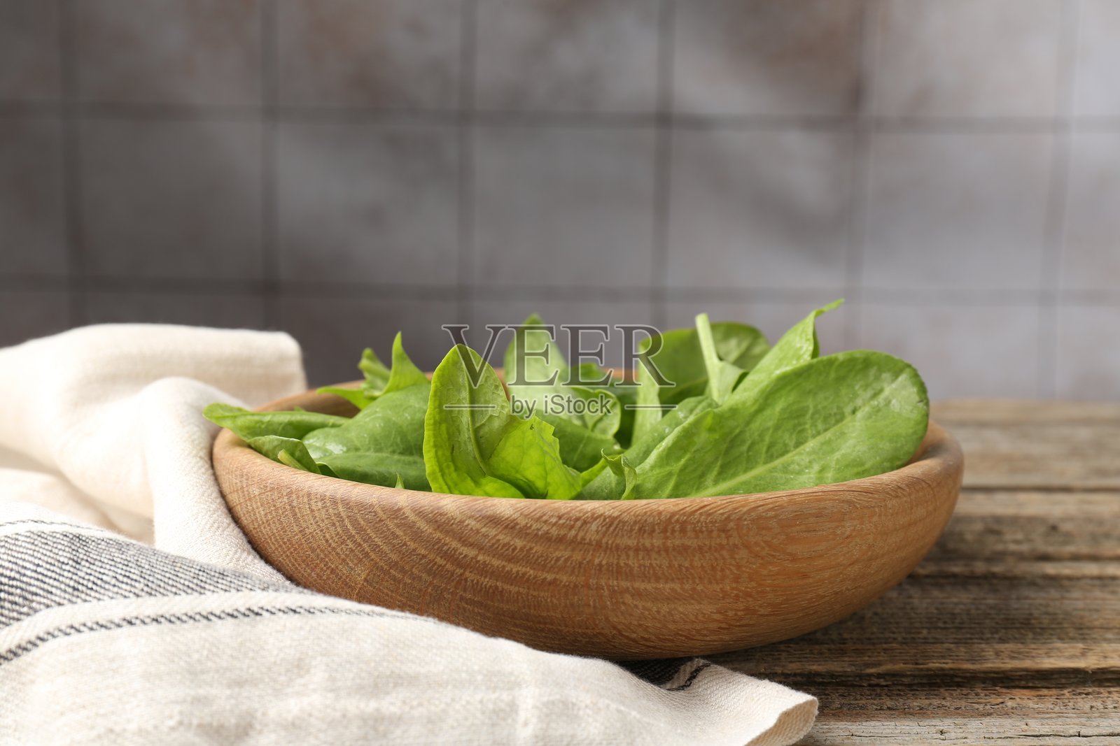 木质桌上碗里新鲜的绿叶酢浆草,特写照片摄影图片